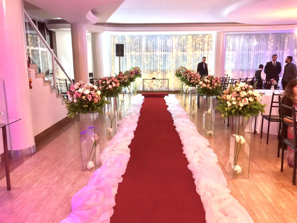 "Interior luxuoso do Salão de Festas Pampulha, decorado para um casamento com mesas, flores e iluminação suave."